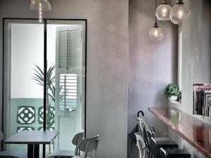 新加坡Rest Chinatown Hotel的用餐室配有椅子、桌子和镜子