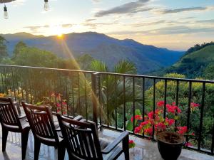 埃拉黄金景观旅馆的阳台配有桌椅,享有山景。