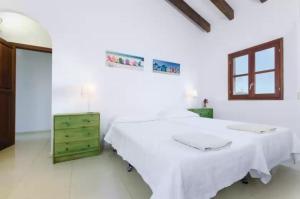 安德拉特斯Puig de Garrafa的白色客房的两张床和绿色梳妆台