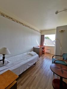 曼达尔SKAP Hostel Mandal的酒店客房配有一张床铺和一张桌子。