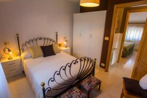 San Pedro de BenquerenciaLOW COST CASA BRAIS的卧室配有一张白色大床和两把椅子