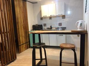 戈多伊克鲁斯Moderno Monoambiente con estacionamiento的一间厨房,内设一个柜台和两个凳子