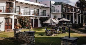 卡法亚特洛斯索西斯酒店的院子里设有桌子和遮阳伞的酒店