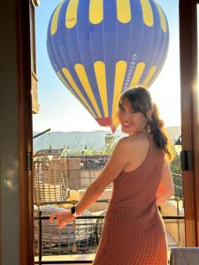 AvcılarAysel Inn House的站在带热气球的阳台上的女人