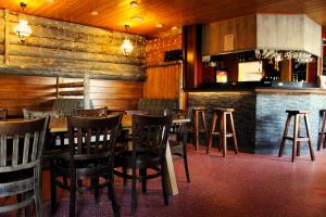 伊瓦洛伊瓦洛河露营酒店的一间设有木墙和椅子的餐厅和一间酒吧