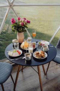 Dolný KamenecGlamping Resort的餐桌,带食物盘和酒杯
