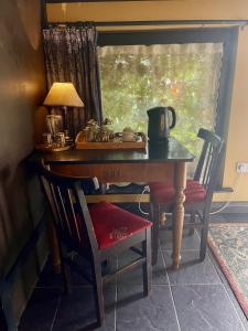巴利瓦根沃特乡村别墅民宿的一张带灯和椅子的旧桌子和一张带窗户的桌子