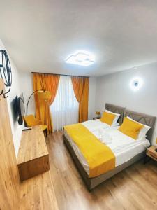 斯科普里Hotel Restaurant Domestika的一间卧室配有一张带黄床单和一张桌子的床。