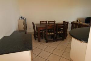 马盖特Strandloper 3的厨房以及带桌椅的用餐室。