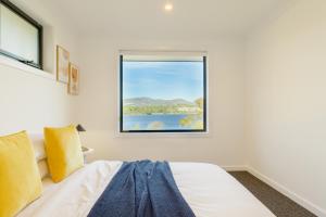 霍巴特Hobart 4-bedroom Spacious Waterfront House的一间卧室设有一张床和一个窗口