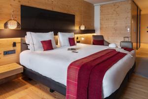 索尔德乌Park Piolets MountainHotel & Spa的卧室配有一张大白色床和红色毯子