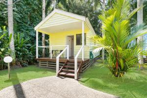 MossmanMossman Resort Holiday Villas的一座小黄色房子,在院子里设有木门廊