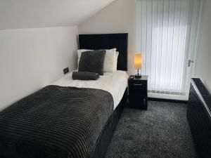 斯肯索普OYO The Avenue的一间卧室配有一张带黑色床头板和灯的床。