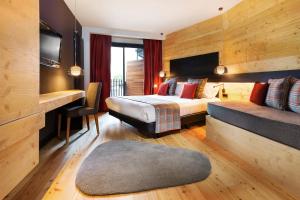 索尔德乌Park Piolets MountainHotel & Spa的配有一张床和一张书桌的酒店客房
