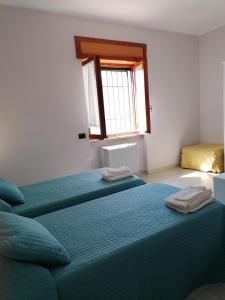 坎波巴索Residenza Guglielmi的一间卧室设有两张床和窗户。