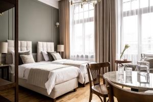 克拉科夫Avanti Palazzo的配有桌子和用餐室的酒店客房内的两张床
