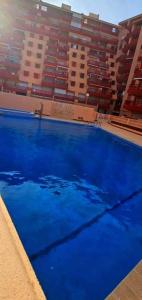 拉曼加戴尔马尔梅纳Apartamento jardin del mar 7.5的大楼前的大型蓝色游泳池