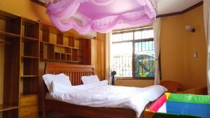 达累斯萨拉姆Luxury Villa Garden的一间卧室配有一张紫色天花板的床