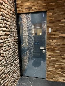 奈梅亨City Spa Nijmegen的砖墙内玻璃门的浴室