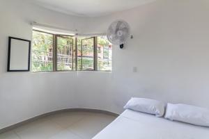 麦德林CASA TURISTICA MACHU PICCHU MEDELLIN的白色的客房配有床和风扇