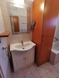 沃罗里尼Oroklini Hideaway的浴室配有盥洗盆、镜子和浴缸