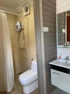 龙运加拉海角之家旅馆的浴室配有卫生间、盥洗盆和淋浴。