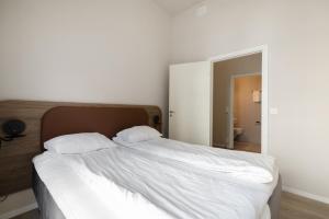 奥斯陆Maya Apartments - Parkveien的卧室内的一张带两个枕头的白色床
