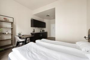 奥斯陆Maya Apartments - Parkveien的带四张床和一张桌子的房间以及厨房