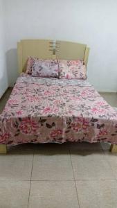 安格拉杜斯雷斯Casa com churrasqueira e piscina, perto de riacho的一间卧室配有一张带粉色毯子和枕头的床。