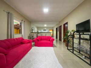 安格拉杜斯雷斯Casa com churrasqueira e piscina, perto de riacho的客厅配有红色沙发和电视