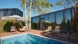 萨卡里亚Velour Hotel Spa Restaurant的一座带游泳池和玻璃墙的房屋