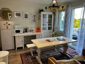InkooMoonloft@VillaSolbacka的厨房配有桌子和白色冰箱。