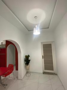 Awlād ‘UmarVilla Maria & Nour的一间白色的房间,配有红色椅子和门