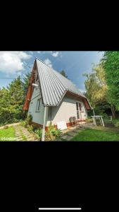 扎沃亚Domek na Hrabkowej-Zawoja的院子中一座带金属屋顶的白色房子