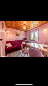 扎沃亚Domek na Hrabkowej-Zawoja的客厅配有红色的沙发和桌子