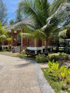 龙运加拉海角之家旅馆的前面有棕榈树的房子