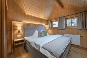 阿尔陶塞安彭帕克斯奥塔西黑根酒店的木制客房内的一间卧室配有一张大床