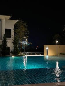 怡保Ins Design Lost World Of Tambun 2BR7pax的一座游泳池,晚上与大楼相连
