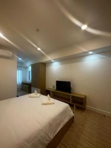 琅勃拉邦Midnight Blue Guesthouse的一间卧室配有一张大床和电视