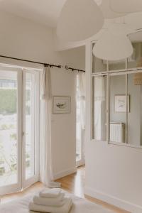 瓦戈兰斯Chez Anne et Grégoire的一间设有白色墙壁和大窗户的客房
