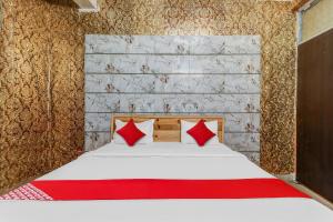 ChinhatFlagship Hotel Sai Palace Near Gomti Riverfront Park的一间卧室配有一张带红色枕头的床