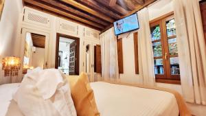 托莱多水边精品酒店的卧室配有一张床,墙上配有电视。