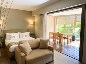 戛纳戛纳圣巴特别墅酒店的一间卧室配有一张床、一张沙发和一张桌子