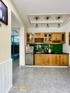 头顿Căn Happy的厨房配有木制橱柜和绿色台面