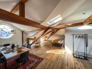 基姆湖畔普林Loft-Wohnung im Herzen von Prien - 100m2 - SmartTV的客房设有木梁、桌子和床。