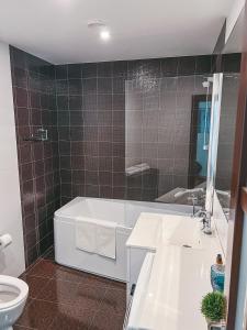 克莱佩达UP 34 FLOOR APARTMENTS的带浴缸、盥洗盆和卫生间的浴室