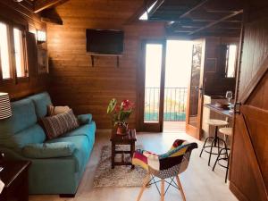 拉奥罗塔瓦Cozy Mountain Chalet的一间带蓝色沙发的客厅和一间厨房