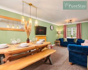 南特威奇Stunning 6-Bedroom House in Nantwich with Parking & Free Wi-Fi by PureStay Short Lets的客厅配有桌子和蓝色沙发