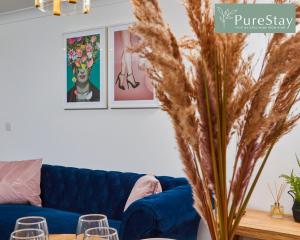 南特威奇Stunning 6-Bedroom House in Nantwich with Parking & Free Wi-Fi by PureStay Short Lets的客厅配有蓝色的沙发和桌子