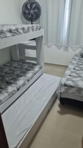 卡马萨里casa confortável的一张位于房间内的白色双层床